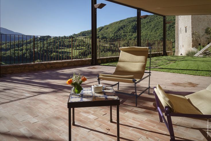 Relaxation area with a hill view, featuring chairs and a decorated table, perfect for moments of tranquility.