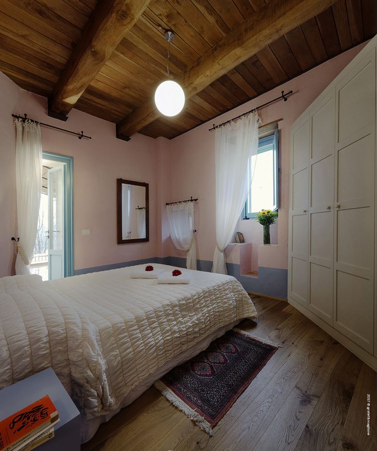 Spacious bedroom with simple decor and natural light flowing in from a window. A tranquil environment.