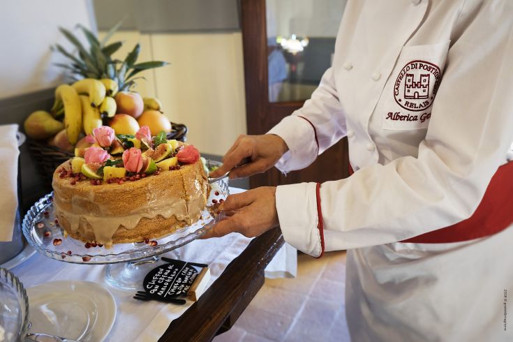 A decorated cake with fruits and flowers, ready to be enjoyed in a family setting.