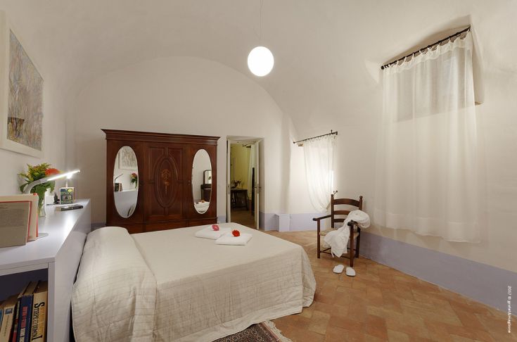 A simple and cozy room in a historic setting, featuring wooden furniture and understated details.