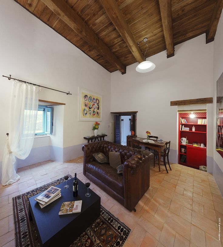 A cozy living room with wooden ceilings and a kitchenette. Ideal space for relaxing moments.