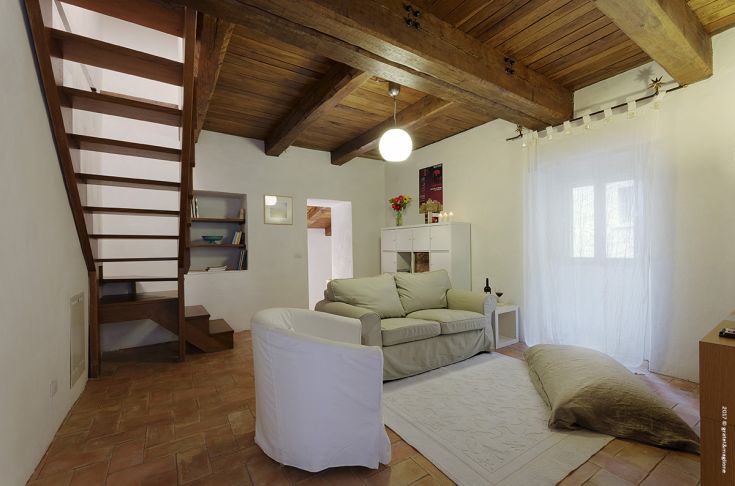 A simple living room with wooden elements and a tranquil atmosphere, perfect for relaxation moments.