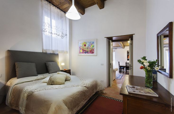 A hotel room featuring a double bed and simple decorations.
