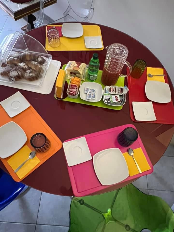A beautifully set table with colorful dishes and a selection of food and drinks for breakfast.