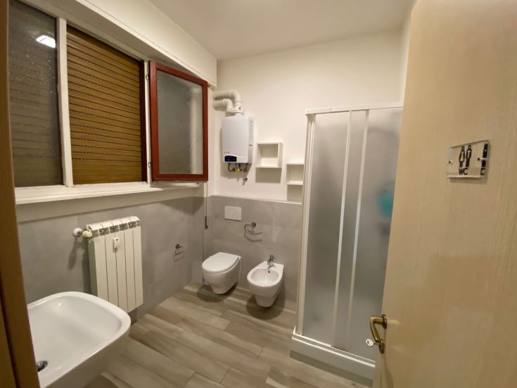 Zeitgemäßes Badezimmer mit Dusche, Bidet und WC, beleuchtet durch ein Fenster und beheizt.