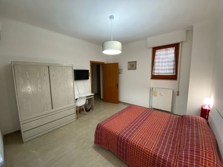 Geräumiger und heller Raum mit gestreiftem Bett und zeitgenössischer Einrichtung, in einem zentralen Bereich gelegen.