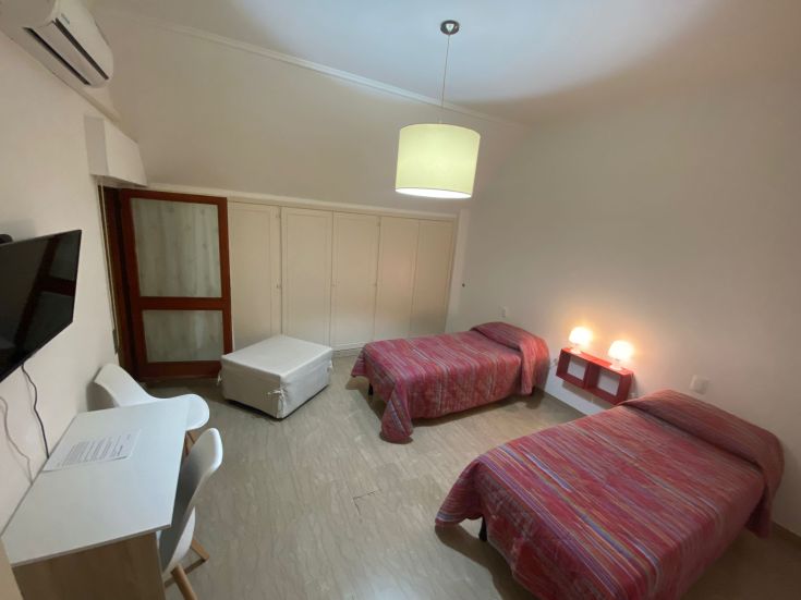 Geräumige und gut beleuchtete Zimmer mit Einzelbetten, ausgestattet mit allen Annehmlichkeiten.