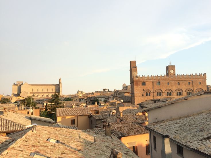 Scena con il duomo e un palazzo in un contesto urbano umbro.