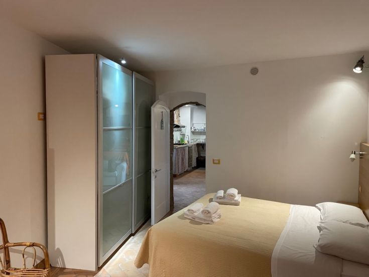 Camera semplice con letto matrimoniale e armadio, situata in un contesto silenzioso e rilassante.