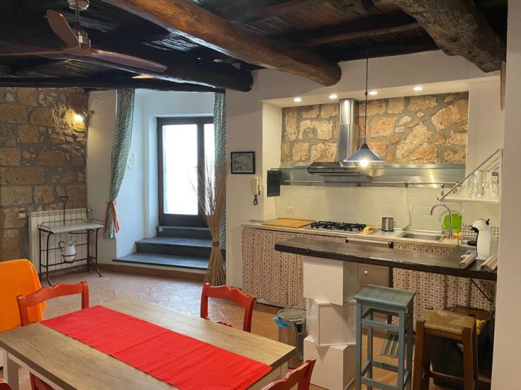 Cucina calda e confortevole con elementi in legno e pietra. Luogo perfetto per trascorrere momenti insieme.