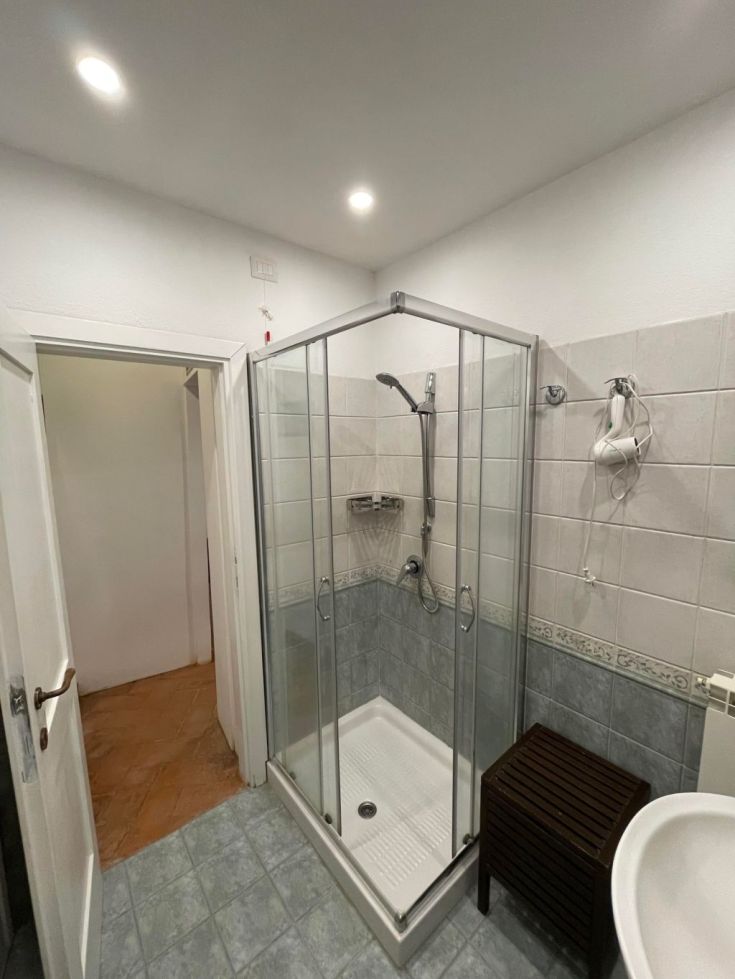Bagno con doccia, semplice e luminoso, con tonalità chiare che rendono l'ambiente accogliente.
