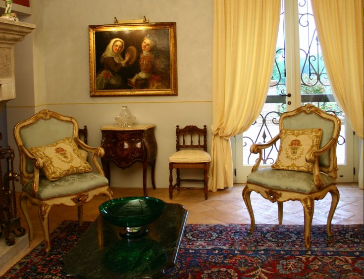 A cozy living room with classic furniture and a painting, creating a warm and understated atmosphere.