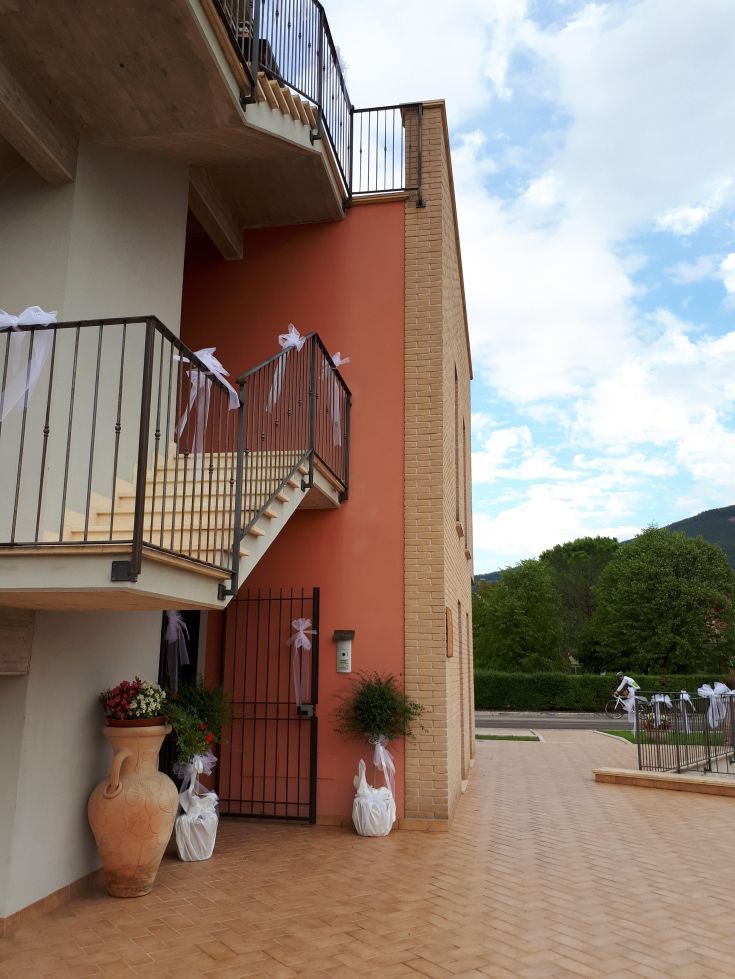 Détail d'un bâtiment avec des escaliers et des plantes, créant une ambiance ordonnée et accueillante.