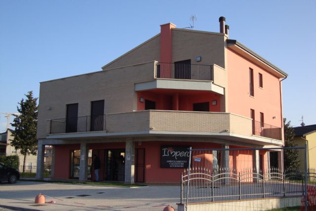 Un edificio residenziale contemporaneo con elementi design, situato in una zona tranquilla e alberata.