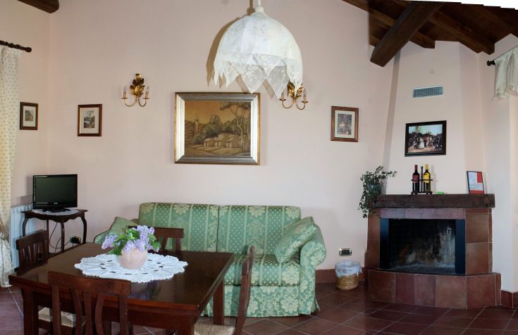 Un soggiorno semplice con divano, tavolo da pranzo e camino, adatto per momenti di relax.