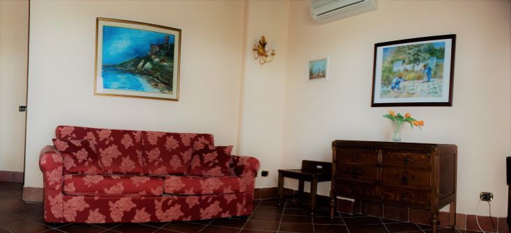 All'interno di un'esclusiva tenuta, un divano con motivi floreali si combina con la luce naturale e i dettagli decorativi delle pareti.