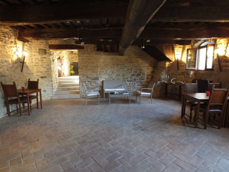 A simple interior of a medieval castle with stone walls and rustic-style furniture.