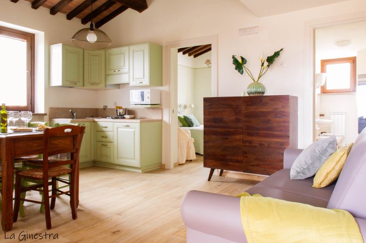 A simple apartment with a functional kitchen and a cozy living area. Natural light and understated details.