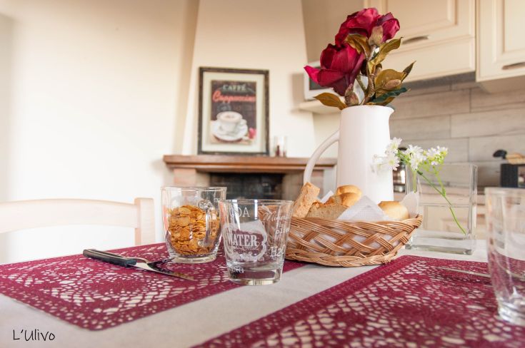 A beautifully set breakfast table adorned with floral decorations in a cozy, simple environment.