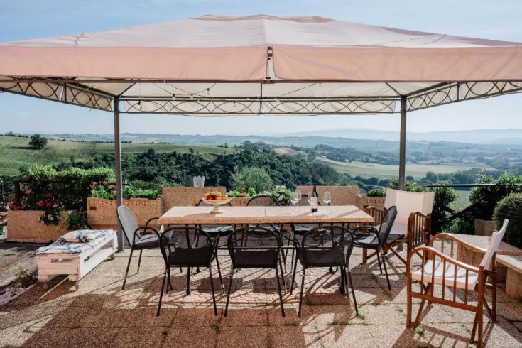 A large gazebo over an outdoor table overlooking the surrounding countryside.