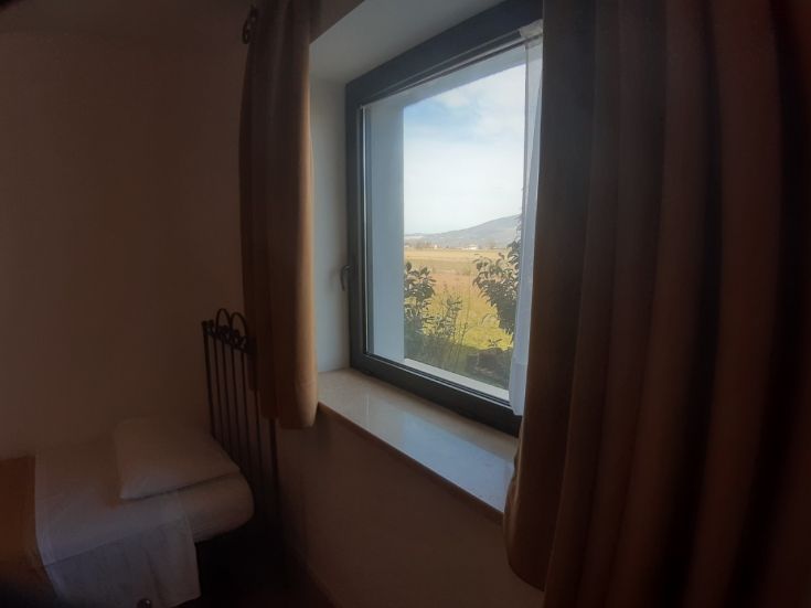 Camera accogliente con panorama sulla campagna umbra, perfetta per momenti di relax.