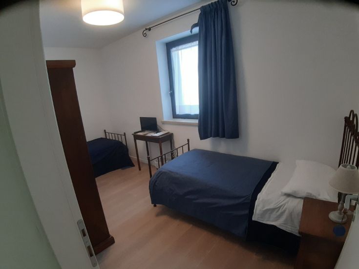 Stanza confortevole con letti singoli, scrivania e ampia luce naturale.