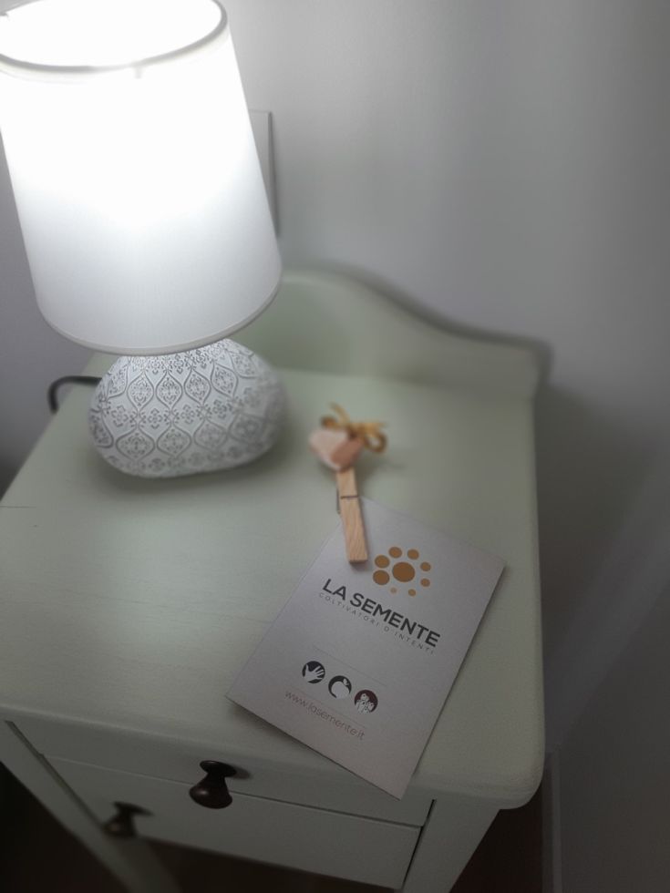 Un tavolo con una lampada e un opuscolo dell'agriturismo, circondato da un ambiente naturale tipico dell'Umbria.