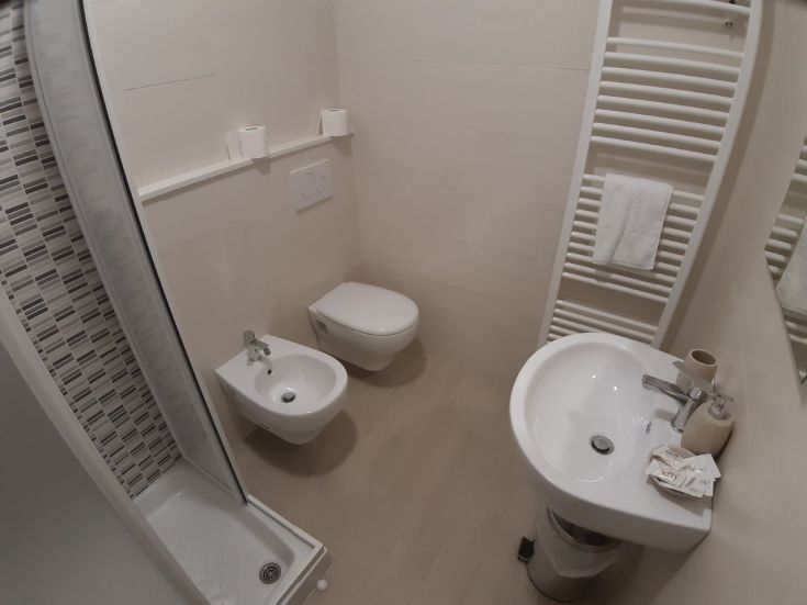 Un bagno moderno con doccia, bidet e lavandino, arredato in modo funzionale e semplice.