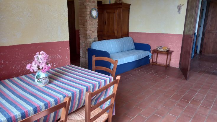 Bright living room with table and sofa, located in a relaxing Umbrian countryside environment.