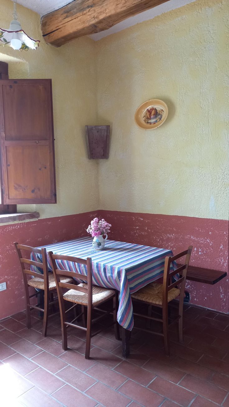 A cozy kitchen corner with a simple table and fresh flowers, perfect for togetherness.