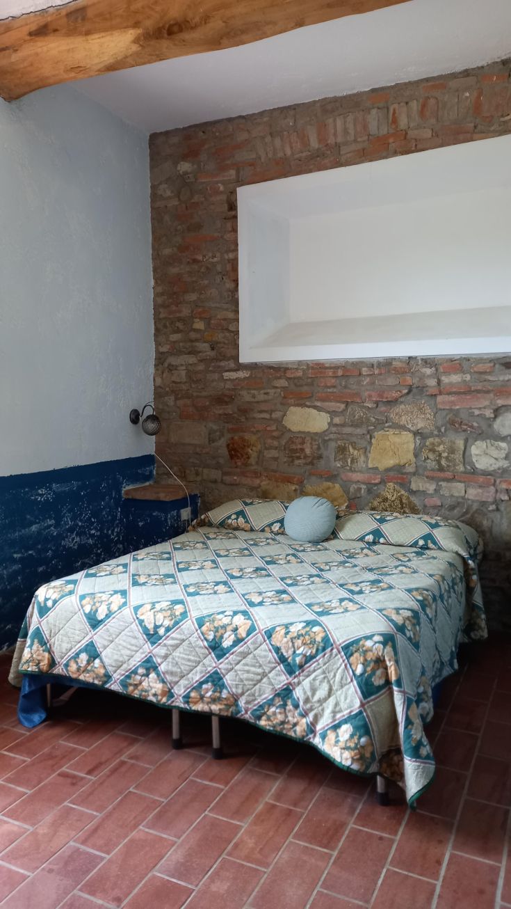 A simple designed room with stone walls, a double bed, and rustic details. Perfect for peaceful moments.