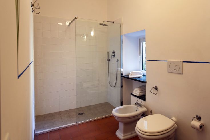 Un bagno arredato con doccia e sanitari, caratterizzato da linee semplici e dettagli funzionali.