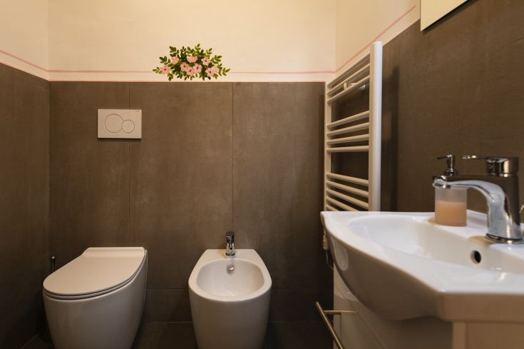 Un bagno moderno con finiture in ceramica e elementi floreali che aggiungono un tocco di freschezza.