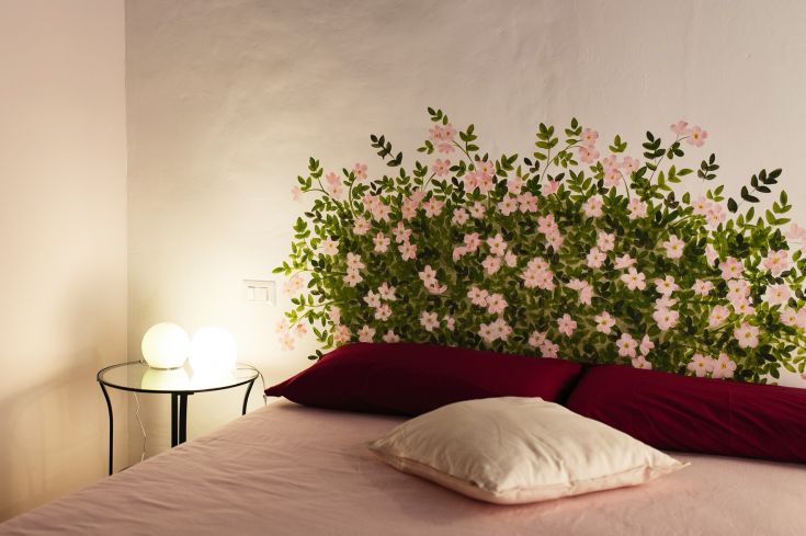 Un'accogliente camera con un affresco floreale e un'illuminazione delicata.