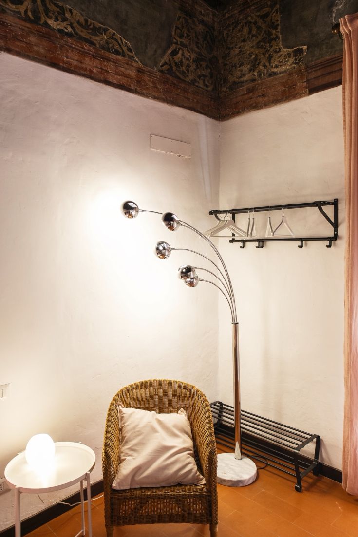 Spazio confortevole con poltrona e lampada contemporanea in un ambiente ben illuminato.