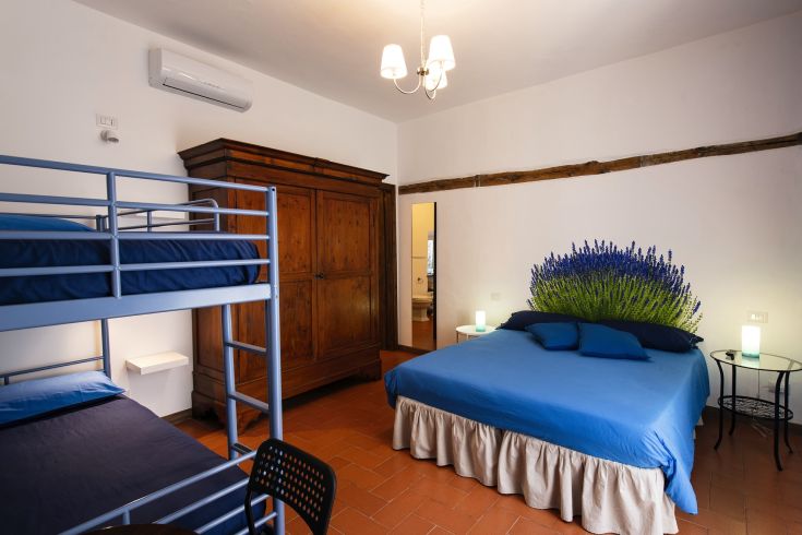 Camera semplice con letti a castello e decorazioni floreali sulle pareti.