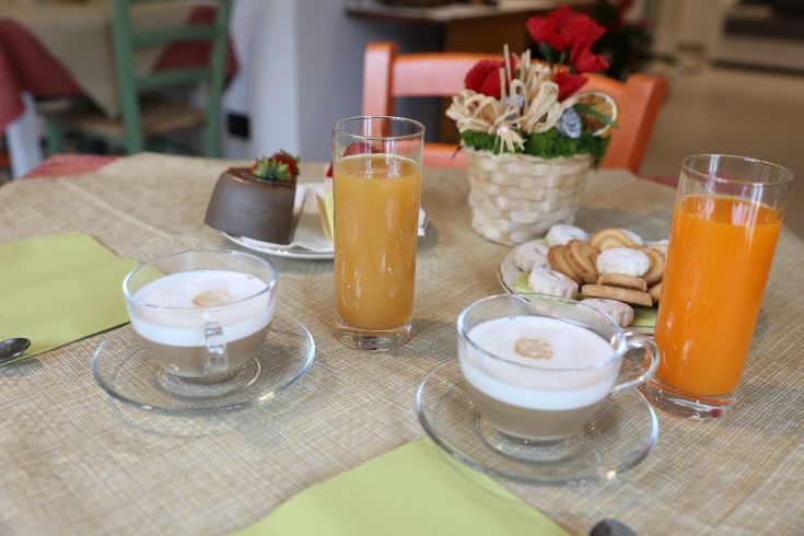 A table set with coffee, fruit juices, and a selection of pastries, perfect for a simple and friendly breakfast.