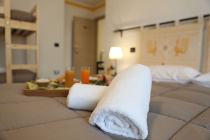 Cozy room in a B&B, simply furnished, with fresh towels and breakfast ready for guests.