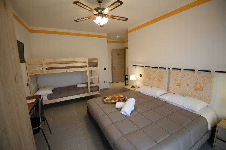 Cozy space with a double bed and bunk beds, perfect for accommodating families.