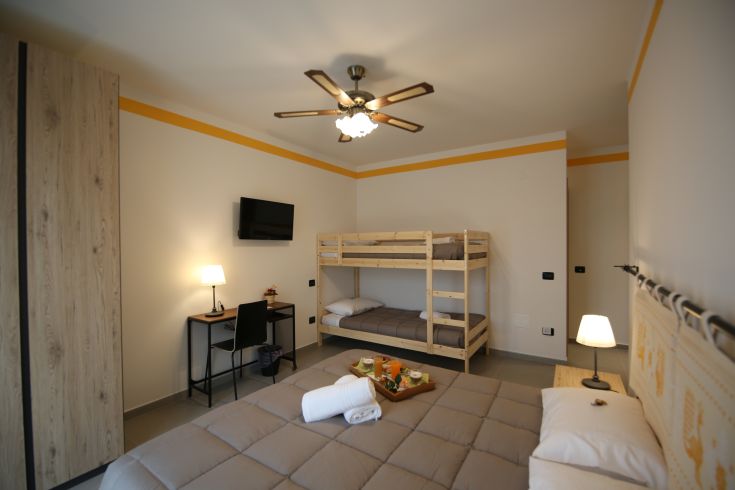 A cozy family room featuring wooden bunk beds and simple decor, perfect for families.