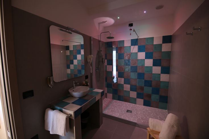 Modern bathroom with colorful tiles and a simple designed sink.