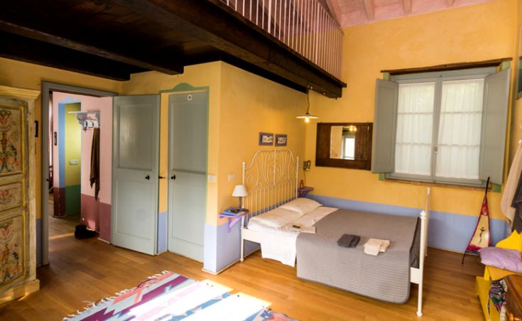 Gemütliches Zimmer mit farbenfrohen Möbeln und einem bequemen Wohnbereich, ideal für entspannte Momente.