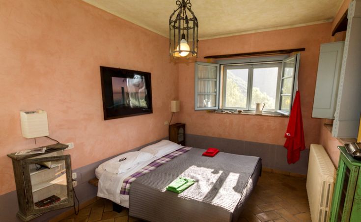 Gemütliches Zimmer mit Blick auf eine grüne Landschaft und einfacher Einrichtung, perfekt für einen entspannten Aufenthalt.