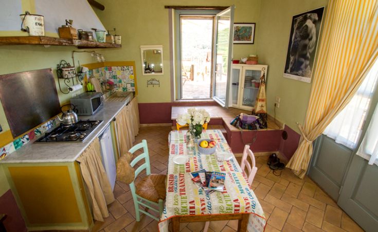 Geräumige und einladende Küche mit bunten Möbeln und einem für die Mahlzeiten gedeckten Tisch.