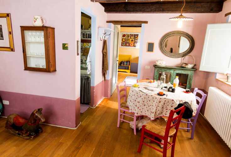 Einfache Speisekammer mit einem gedeckten Tisch und leuchtenden Farben, typisch für ein Agriturismo in Umbrien.
