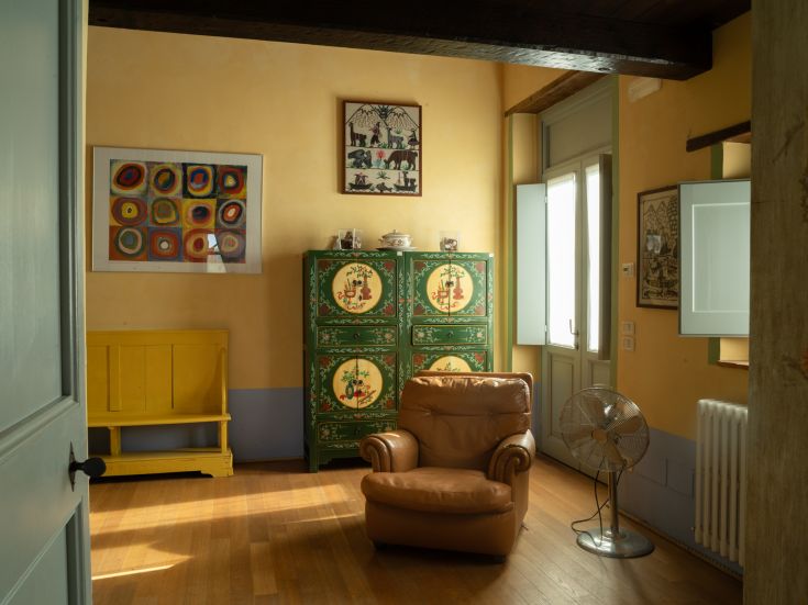 Ein gemütlicher Innenraum mit bunten Möbeln und natürlicher Beleuchtung, ideal zum Entspannen und Arbeiten.