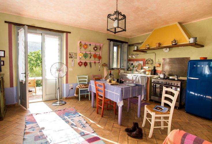 Ein heller und einladender Raum in einem Bauernhaus, mit warmen Farbtönen und einfacher Einrichtung.