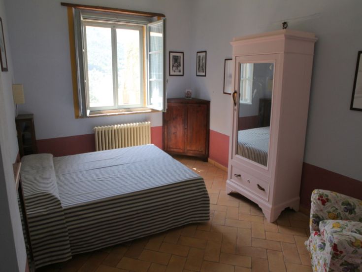 Gemütlicher Raum mit Doppelbett, Kleiderschrank und grundlegenden Möbeln, perfekt für Entspannungsmomente.