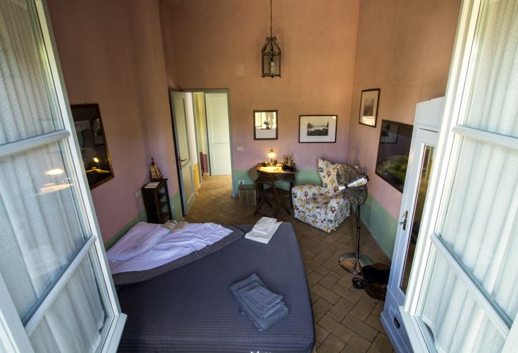 Einfaches Zimmer mit gestrichenen Wänden und gemachten Betten. Ein entspannender Raum mit guter Beleuchtung.