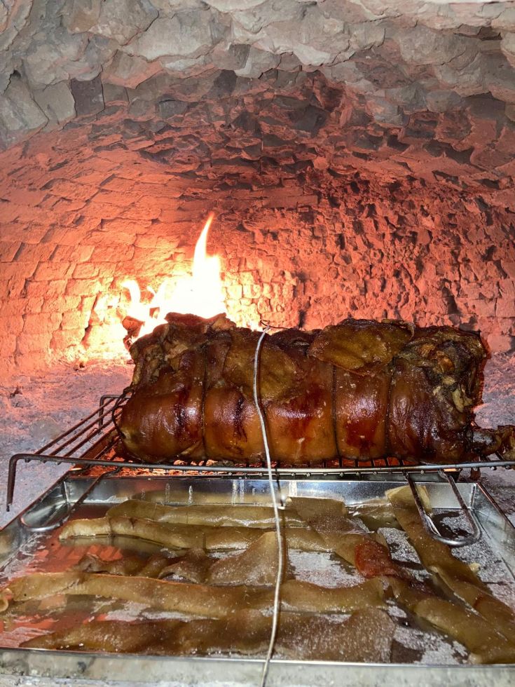 Ein rustikaler Braten, langsam in einem Holzofen gegart, mit intensivem Geschmack und goldener Kruste, bereit zum Genießen.